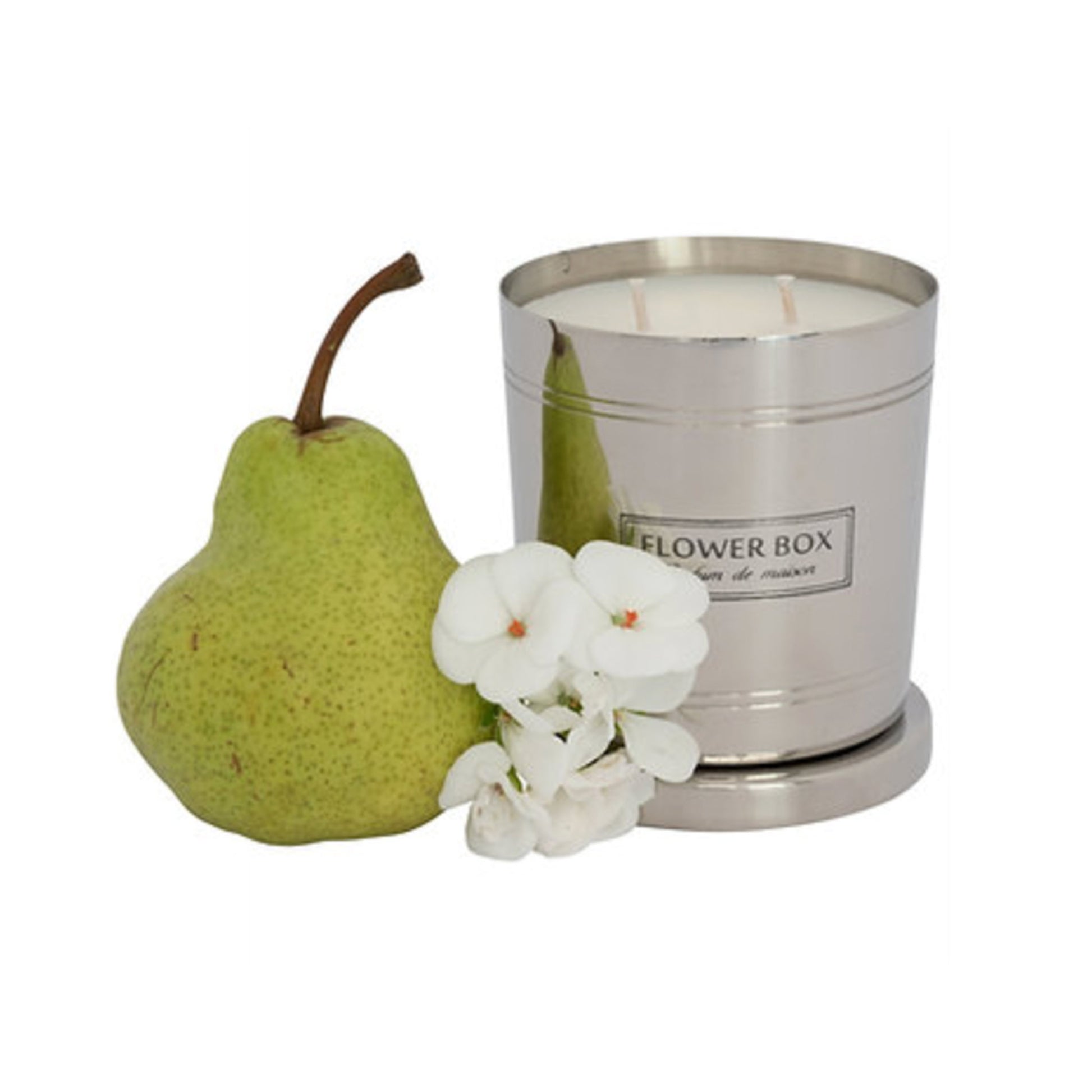 Image of a silver, brushed metal candle container with three wicks and a matching circular base. A rectangular label with black text on a white background reads "FLOWER BOX Pufum de maison". In front of the candle is a pear and a flower. The background is white.